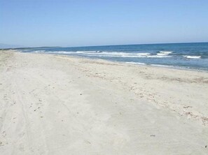 A beach with a sandy shore and a clear view of the ocean.