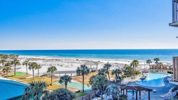 A resort with a pool, beach access, and palm trees. - 2BR Renovated Beachfront at Pelican, Stunning Ocean View, Pools Beach Chairs (Destin)