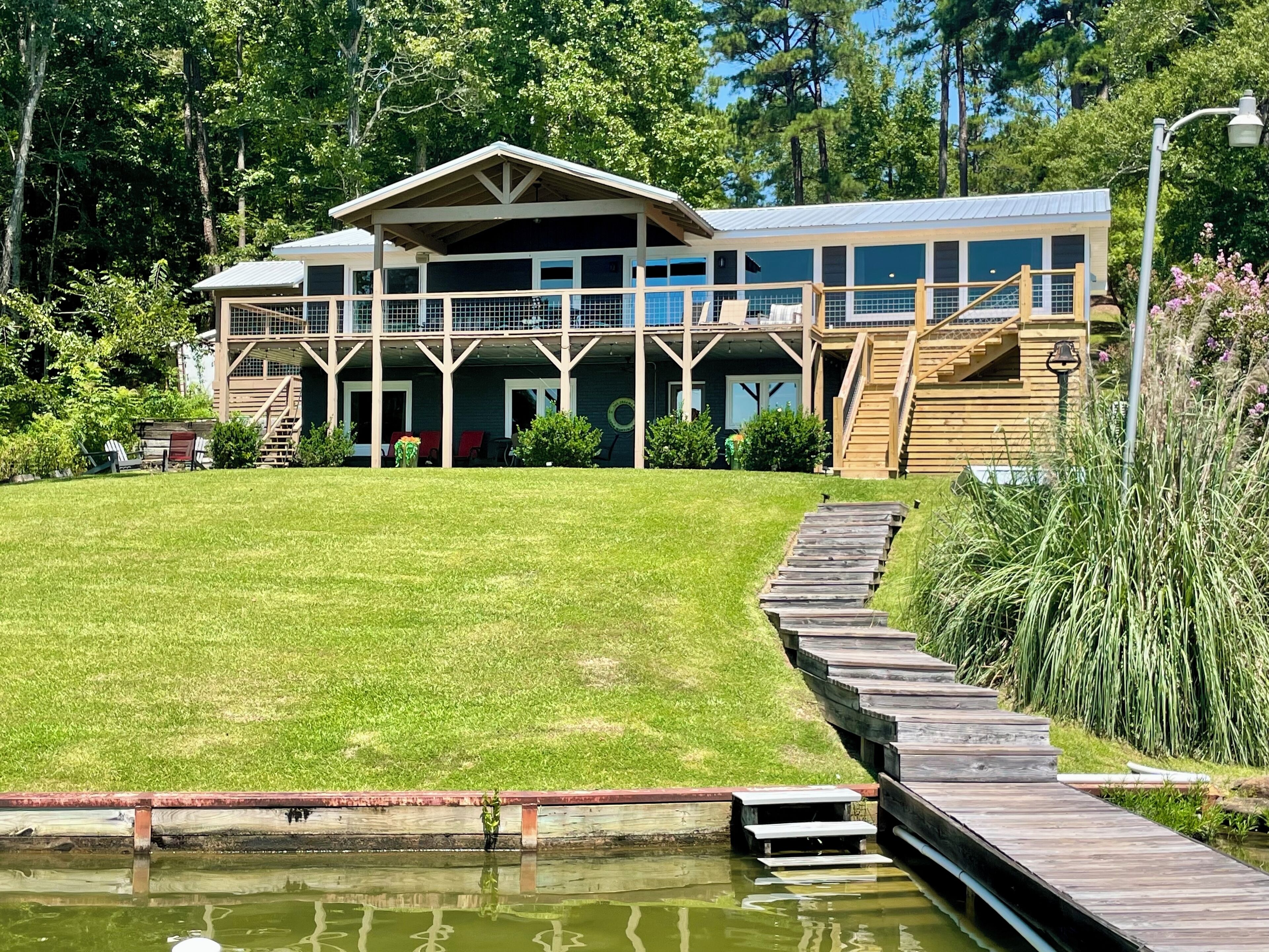 Un grand bâtiment à plusieurs étages, doté d’un porche couvert et d’une terrasse en bois.