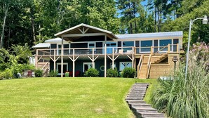 A large, multi-story building with a covered porch and a wooden deck. - Spring special! Enjoy Lake Martin at its best! (Jacksons Gap)