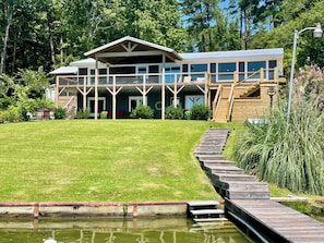 A large, multi-story building with a covered porch and a wooden deck. - Spring special! Enjoy Lake Martin at its best! (Jacksons Gap)