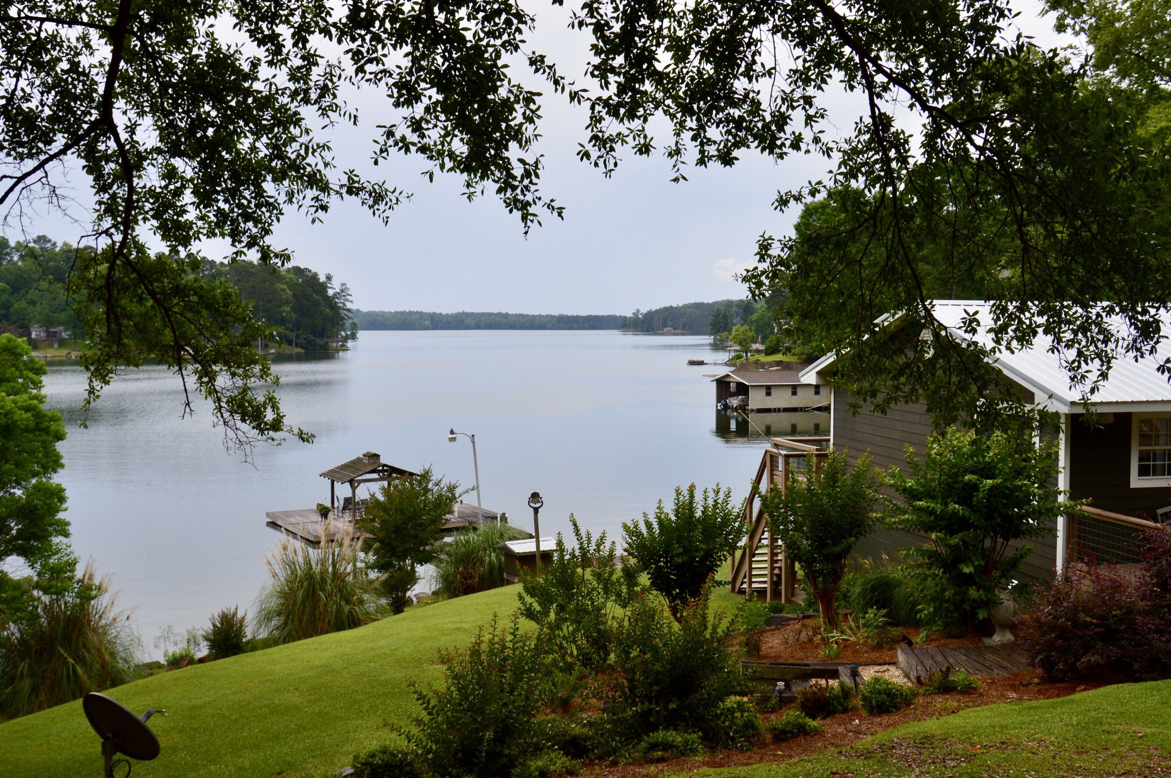 Une propriété au bord du lac, comprenant une maison, un quai et une végétation luxuriante.