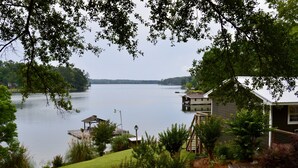 A lakeside property with a house, dock, and lush greenery. - Spring special! Enjoy Lake Martin at its best! (Jacksons Gap)