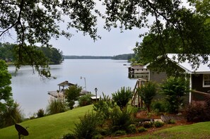 A lakeside property with a house, dock, and lush greenery. - Spring special! Enjoy Lake Martin at its best! (Jacksons Gap)