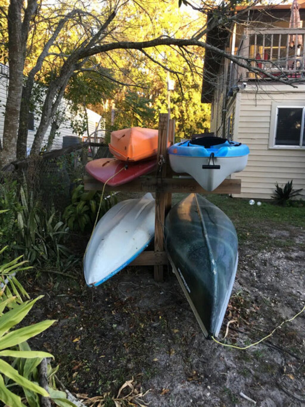 Une structure en bois avec plusieurs kayaks et un canoë.