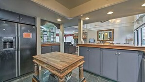 A kitchen with a wooden table, grey cabinets, and a large mirror. - Steps to Bear Mountain & Golf Course Spacious 4BR Prime Moonridge Location (Big Bear Lake)