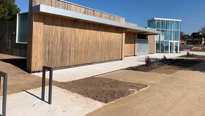 A modern building with a wooden facade and a glass entrance. - 3 *** FEET IN THE WATER, FACING THE SEA, access to the Beach,  F3 BRETAGNE SUD (Clohars-Carnoët)
