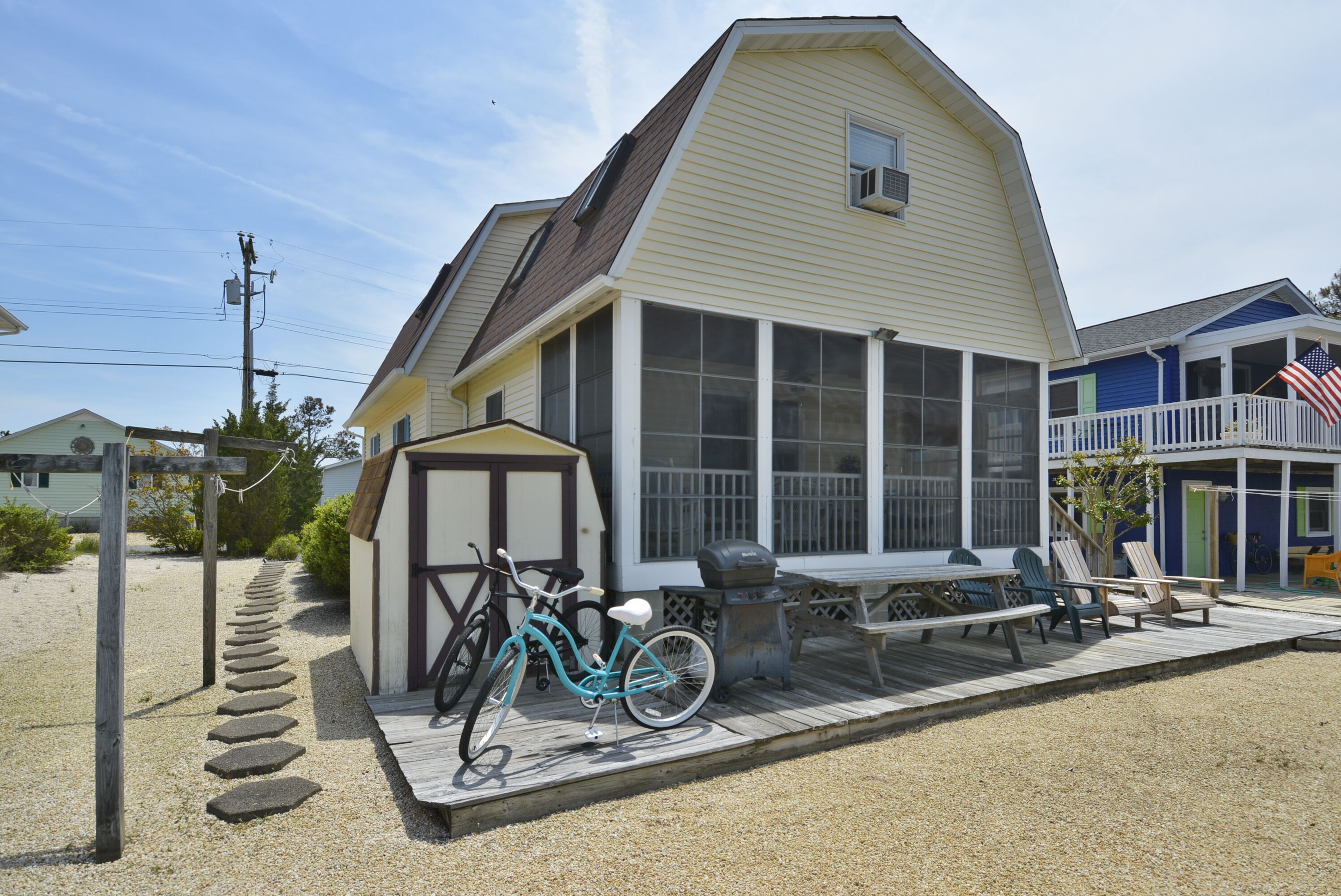 Una casa con porche, bicicleta y mobiliario de exterior.