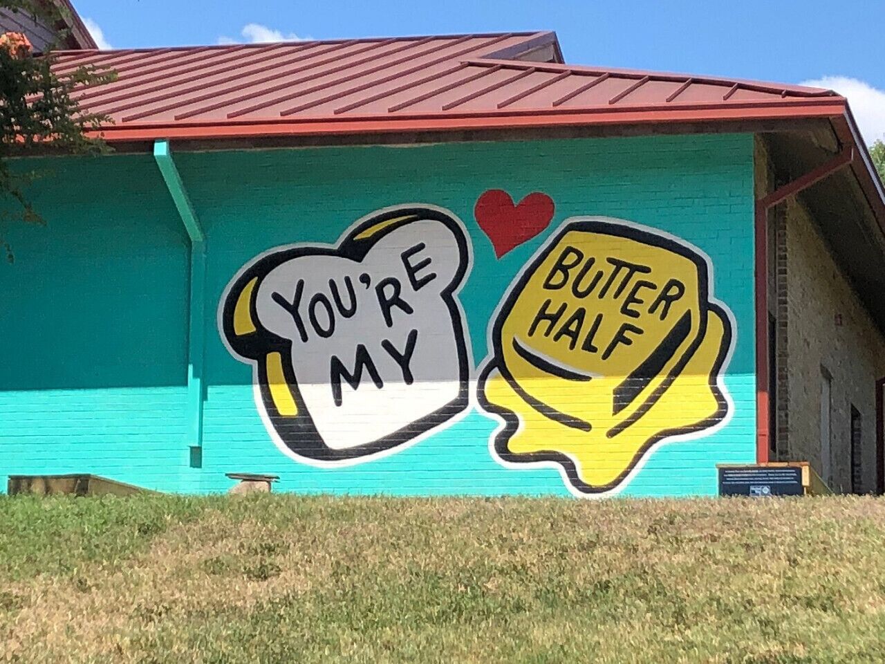 A mural with the text "You're my butter half" on a building.