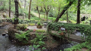 Un jardin paisible avec un petit ruisseau, des bancs en bois et un panneau indiquant le numéro 14652.