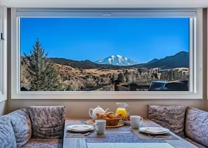 A breakfast setup with croissants, juice, and coffee on a table with a mountain view. - Hot-Tub, Amazing Views, Family/Groups, Private (Glenwood Springs)