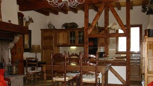 Comedor rústico con sillas de madera y alfombra roja.