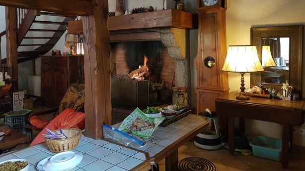 Un ambiente acogedor con chimenea, vigas de madera, un reloj y un espejo.