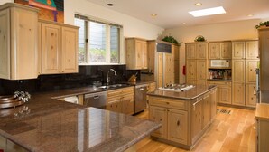 A spacious kitchen with wooden cabinets, granite countertops, and a central island. - Luxury Family Retreat. Ski-in Ski-Out.  Spectacular Mountain Views.  Sleeps 12  (Snowmass Village)