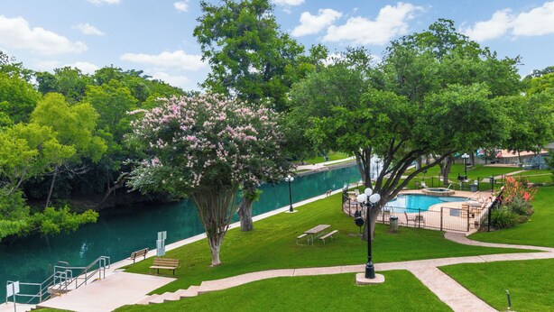 Un parc avec une piscine, une rivière et un pont.