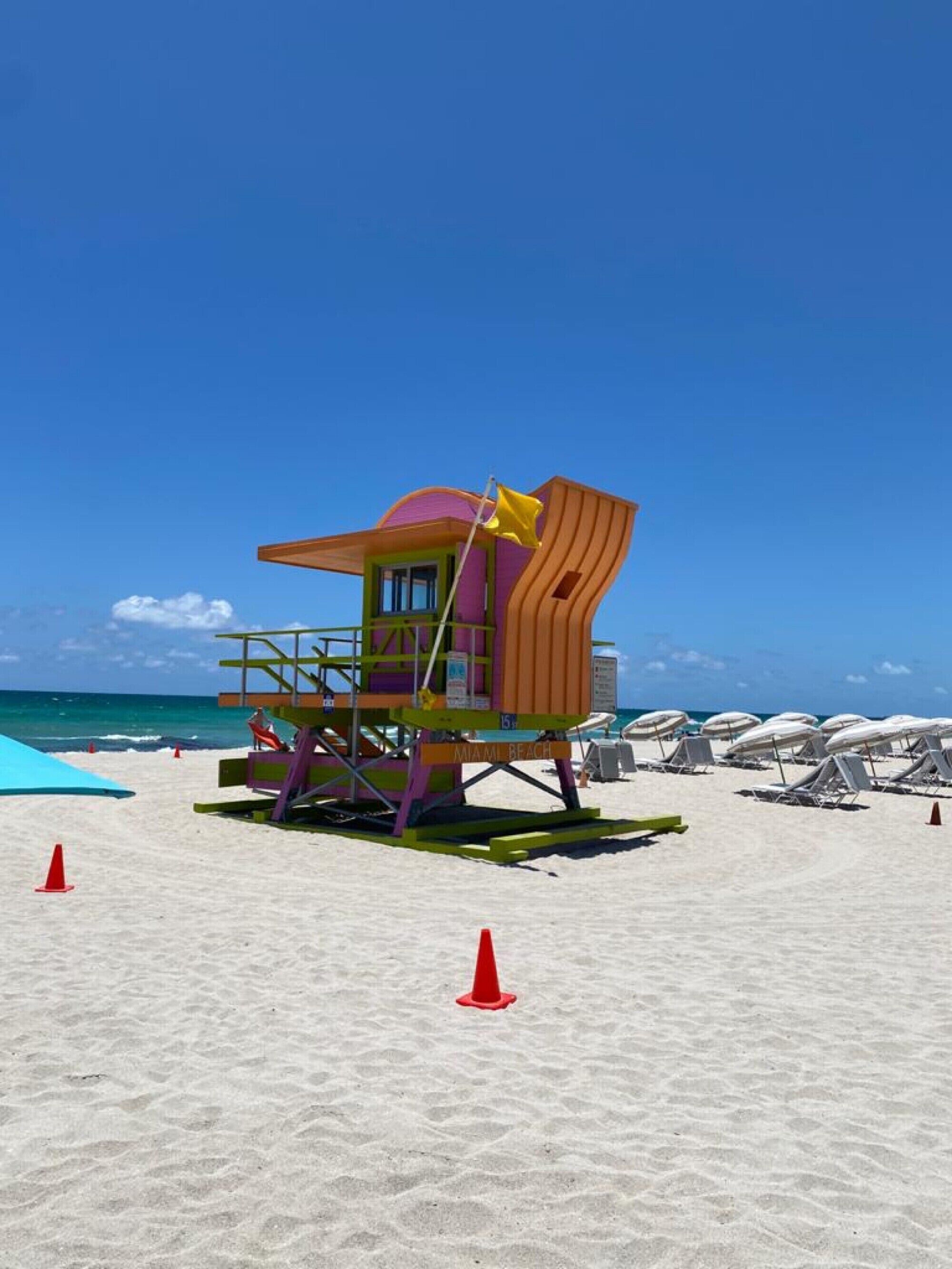 A lifeguard tower on a beach with a clear blue sky.