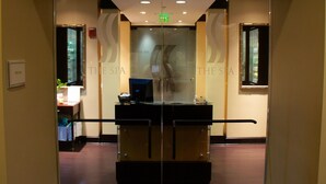 Un área de recepción con puerta de cristal, mostrador de recepción y un letrero que dice 'The Spa'.