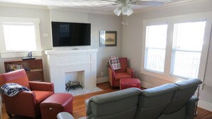 A living room with a fireplace, a television, and a ceiling fan. - A house in the historic bishop's art district (Dallas)