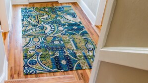 Una escalera de madera con un tapete estampado que lleva a una puerta blanca.