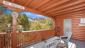 A wooden deck with a metal railing, a white chair, and a table. - Quaint Cabin With Spectacular Views Of The Granite Dells, Great Hiking/Kayaking! (Prescott)