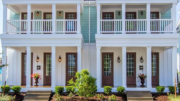 A two-story house with a front porch, a central chimney, and a symmetrical facade. - 404A The Hilltop House | 4BR/3.5BA | Balcony (Virginia Beach)