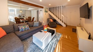 A modern living room with a gray sectional sofa, a white coffee table, and a staircase leading to an upper level. -  Lake and Mountain Escape (Incline Village)