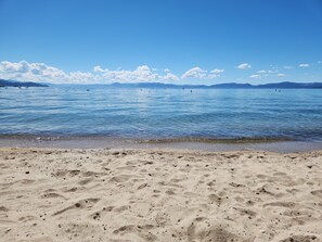 A beach with clear blue water, a sandy shore, and distant mountains. - Lake and Mountain Escape (Incline Village)