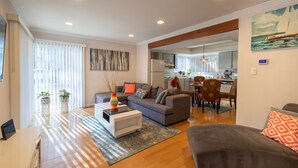A modern living room with a sofa, coffee table, and a dining area with chairs. -  Lake and Mountain Escape (Incline Village)