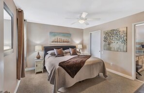 A bedroom with a bed, two bedside tables with lamps, a ceiling fan, and artwork on the walls. - ❤️of DWTN on the RIVER/Walk 2 BROADWAY & ALL/❤️2KING BDS/2BA/Free PRKG/POOL!🎸🎻 (Nashville)