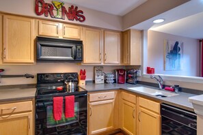 Enjoy cooking in this kitchen with light cabinetry, stainless steel range, and microwave.