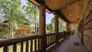 A wooden cabin with a covered porch, large windows, and a view of surrounding trees. - Luxury Ski or Hiking retreat- 2 KING beds and more! (Park City)