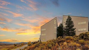 Dos edificios modernos con cielo despejado y atardecer.