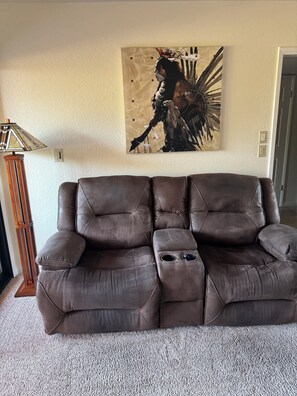 A brown leather sofa with a footrest and cup holders, a wall-mounted abstract painting, and a tall floor lamp. - 4th Floor - Bldg 14 - Views of Pool 5, Golf Course & Mountains (Phoenix)