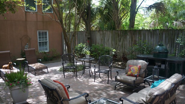 An outdoor patio with patio furniture, a barbecue grill, and a potted plant.