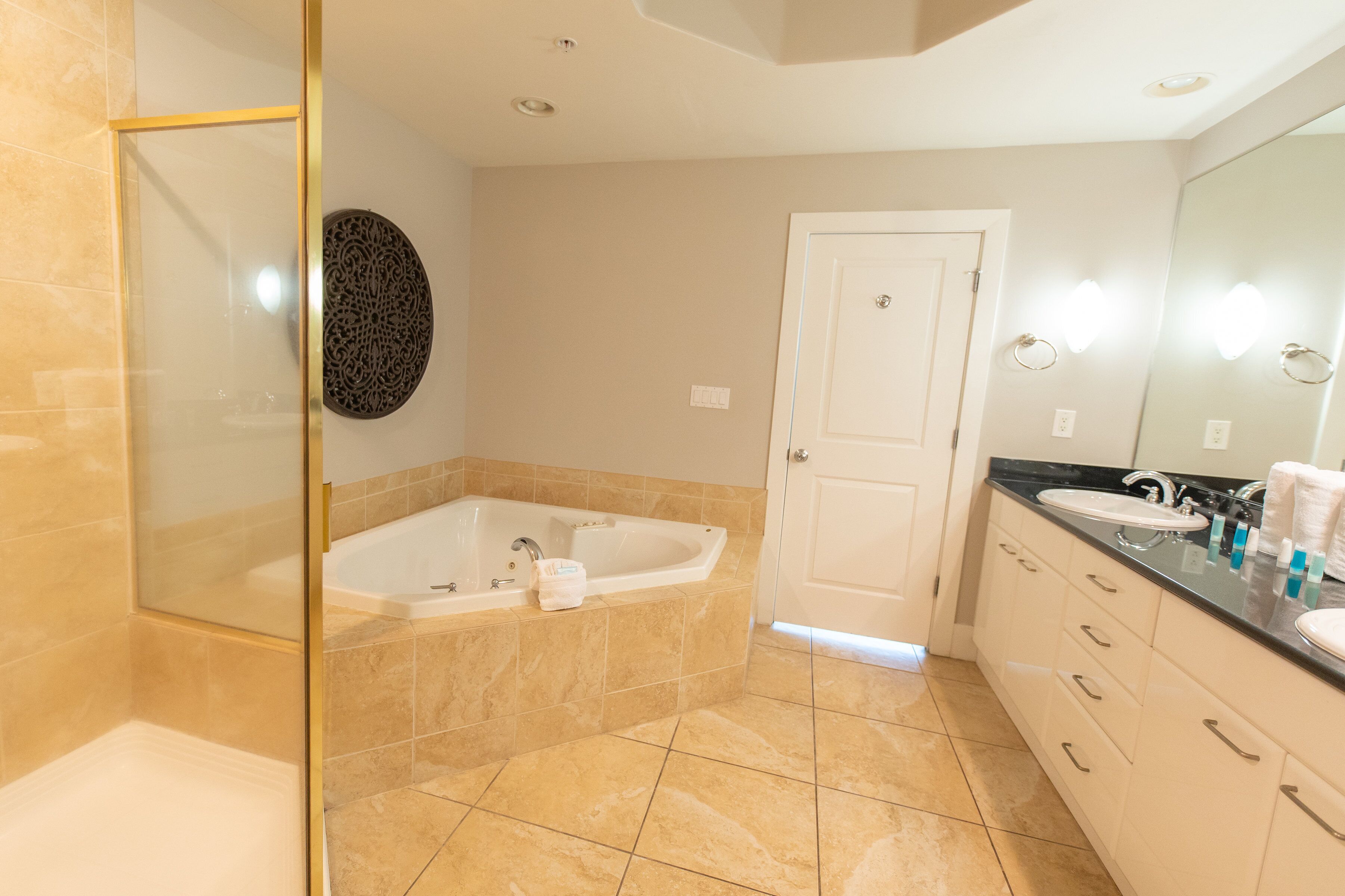 Une salle de bain moderne dotée d’une douche à parois de verre, d’une baignoire sur pieds et d’un meuble-lavabo avec un évier et un miroir.