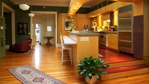 Eine moderne Küche mit Holzschränken, einem Edelstahlkühlschrank und einer Bar.