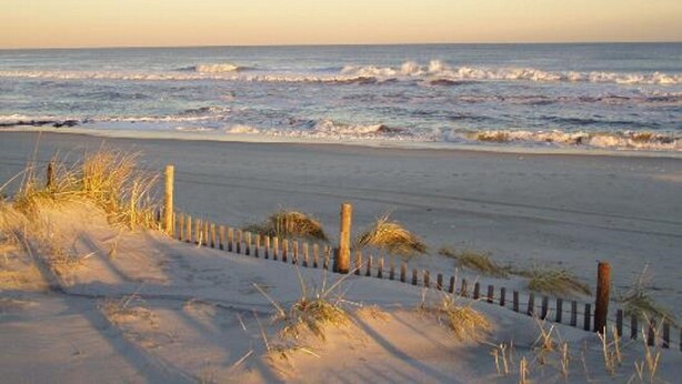 A beach with a wooden fence and sand dunes. - Best Location In LBI! Walk To Everything (Beach Haven)