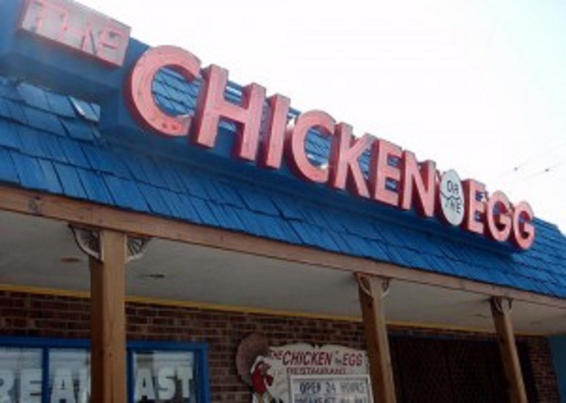 Een gebouw met een bord waarop 'CHICKEN & EGG' staat.