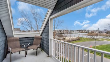 Relax on the balcony with a view of the surrounding residential area, featuring a body of water and houses in the distance.