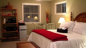 Un dormitorio con una cama, un escritorio, una silla, una estantería y una pequeña mesa de madera.