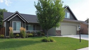 A residential house with a front yard, a driveway, and a garage.