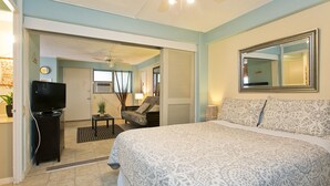 A bedroom with a large bed, a television, a chair, and a mirror on the wall. - The Modern Suite -Waikiki Center Great Rates!! HK#112 (Honolulu)
