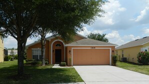 A residential house with a garage, a driveway, and a well-maintained lawn. - Private Villa For Holiday Rental (Clermont)
