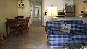 Un espace de vie compact comprenant un coin repas, une kitchenette et un canapé.