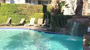 A clear swimming pool with lounge chairs and a waterfall feature. - Completely Remodeled 1 Bedroom -Extra-Large In Las Palmas (Saint George)