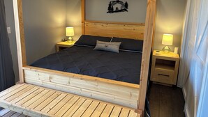 A four-poster bed with a wooden frame, two bedside tables with lamps, and a wall-mounted decoration. - Completely Remodeled 1 Bedroom -Extra-Large In Las Palmas (Saint George)