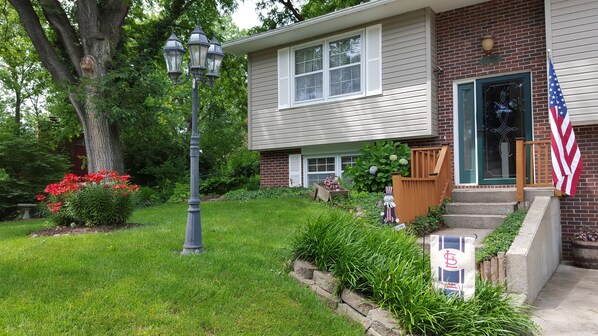 A residential house with a front yard, a street lamp, and an American flag.