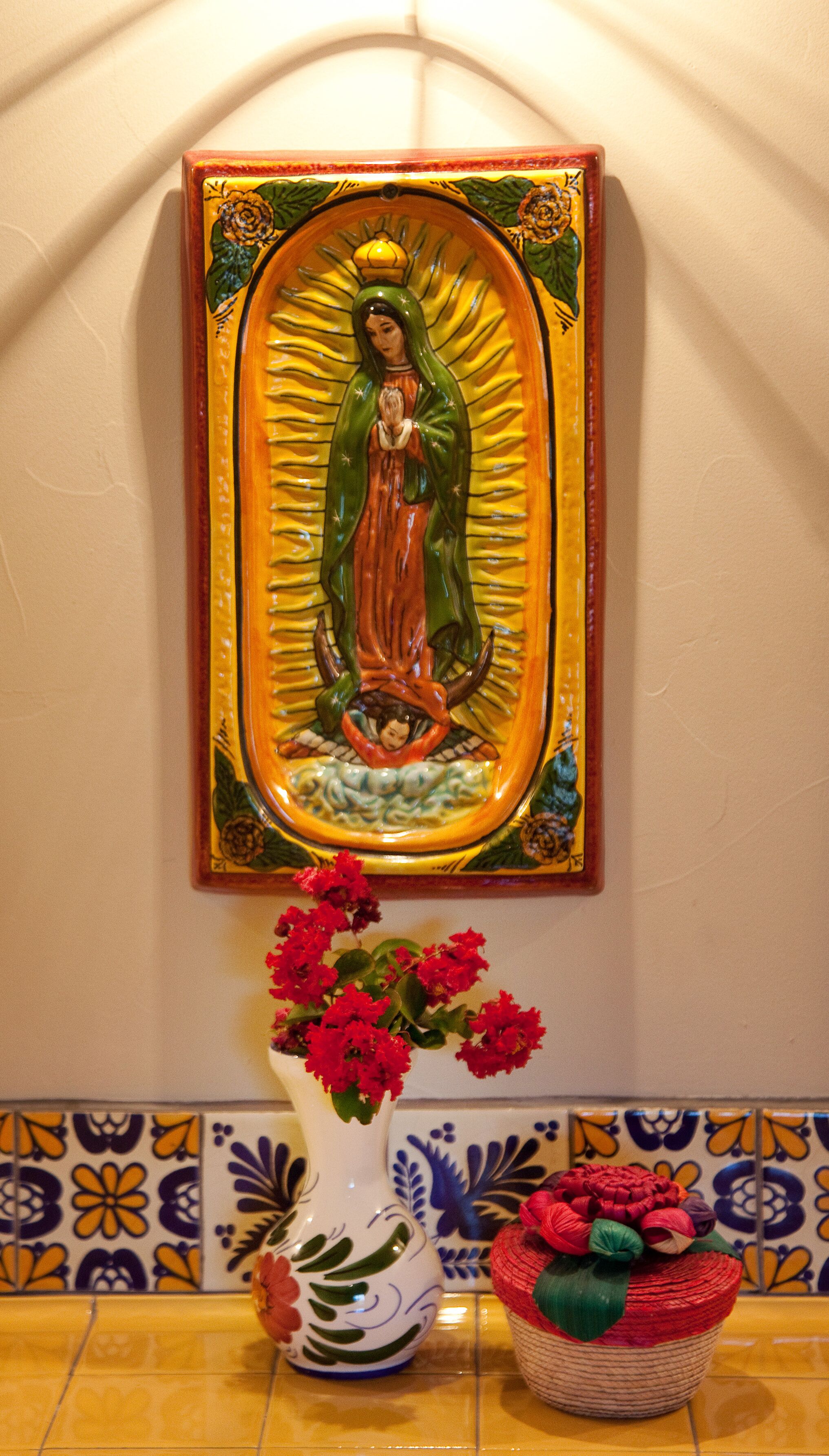 A religious icon with a vase of flowers in front.