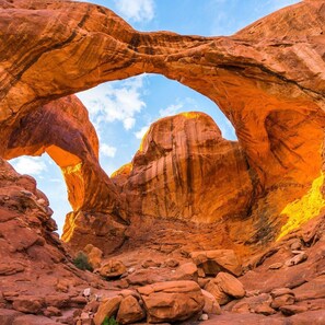 A natural rock arch formation with a clear sky above.