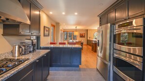 A modern kitchen with dark cabinetry, stainless steel appliances, and a central island.